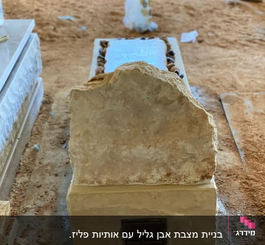 מצבה מאבן עם אבנים קטנות מסביב